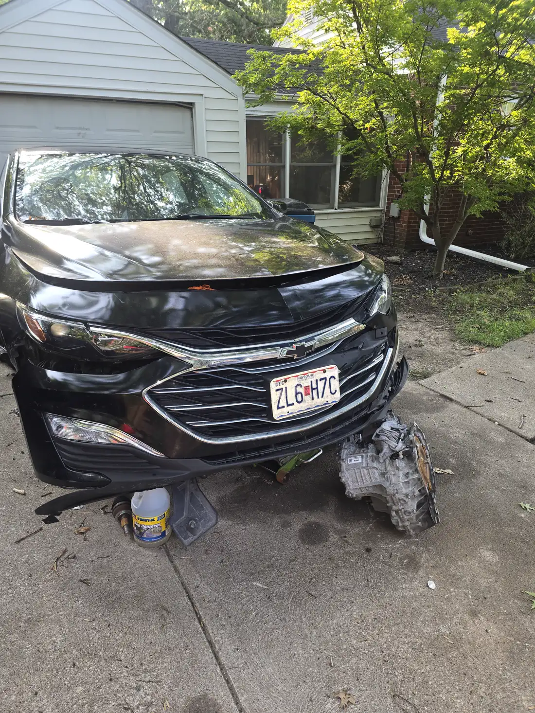 Transmission removed from a sedan, sitting on the customer's driveway in front of the car